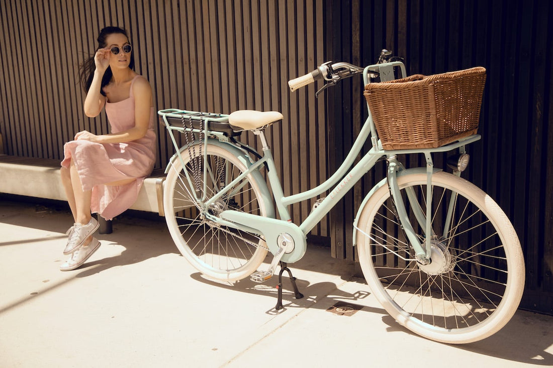 Woman sitting with her Lekker Bikes Jordaan ebike with wicker basket in Australia
