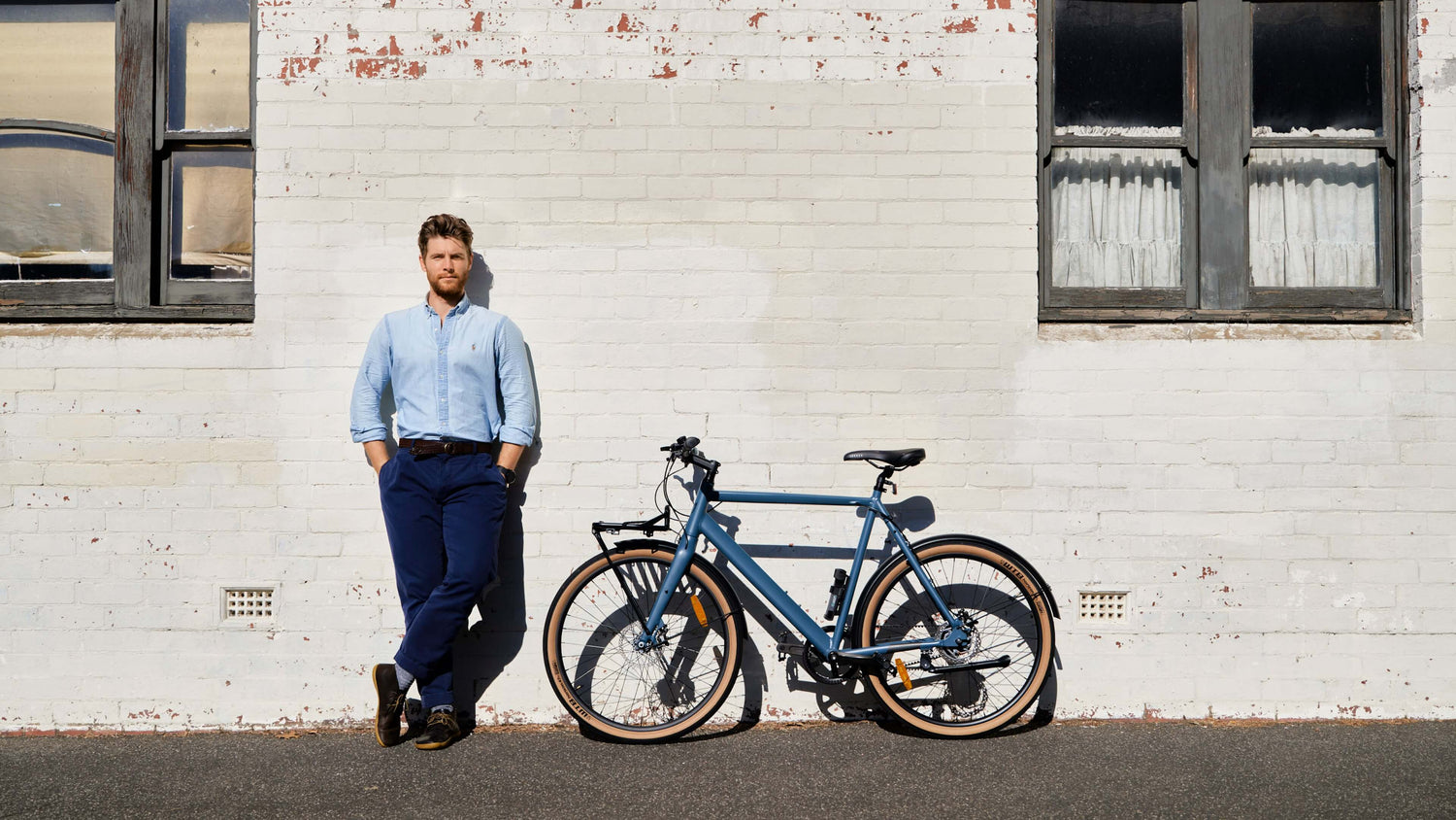 man standing next to conventional amsterdam bike